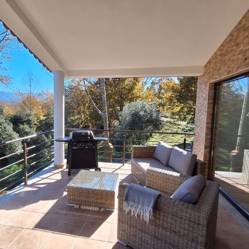 A terrace with brown tiles and a view of trees and the sky